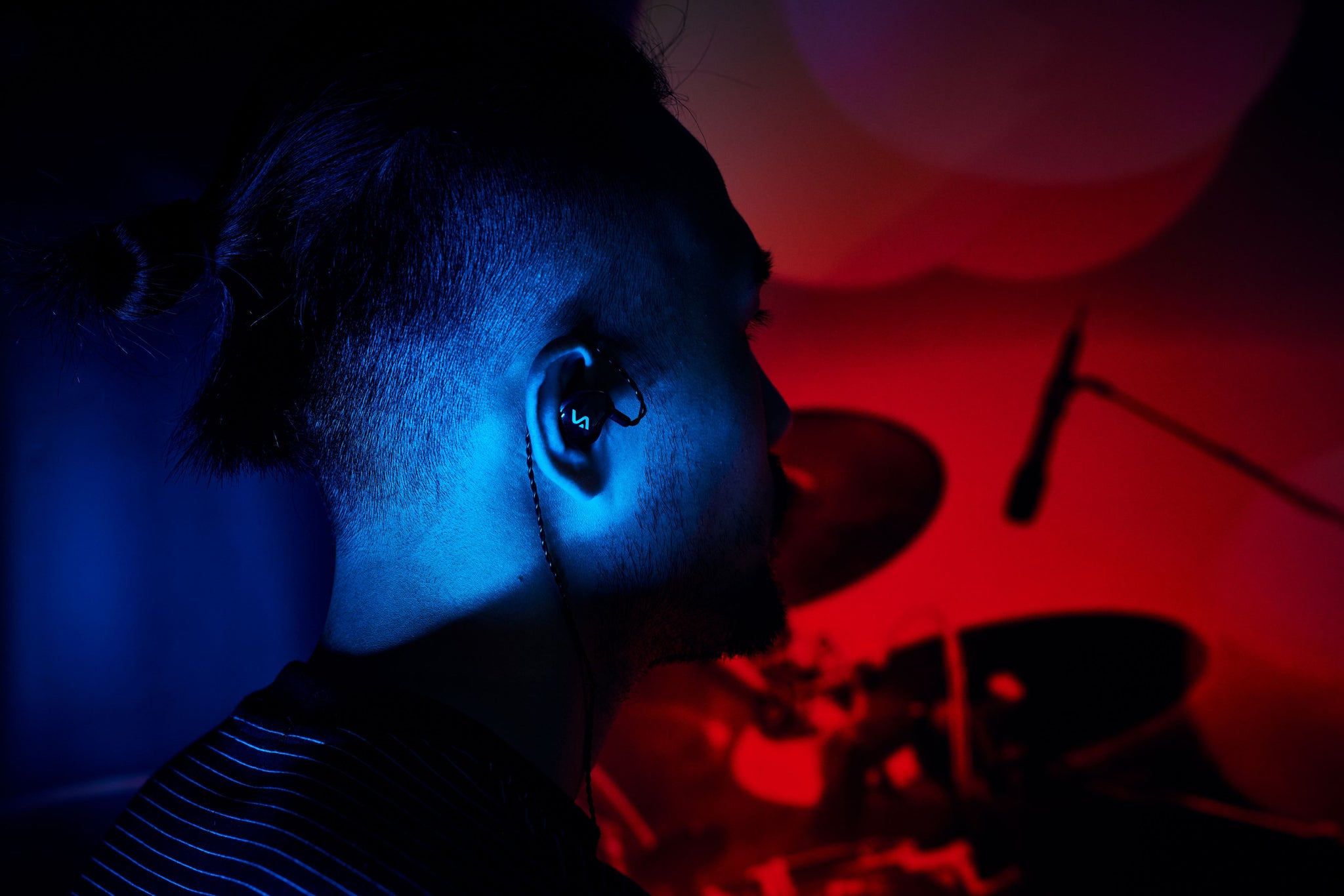 <img src="A man wars an in ear earphone .jpg"alt="A musician wears Velacy in ear earphone to perform.pr">