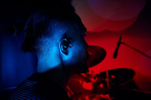 <img src="A man wars an in ear earphone .jpg"alt="A musician wears Velacy in ear earphone to perform.pr">